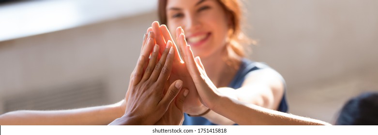 Horizontal photo banner for website header design, group of diverse young people giving high five feels excited close up focus on stacked palms. Respect and trust, celebration and friendship concept - Shutterstock ID 1751415818