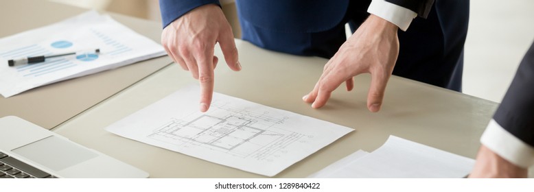 Horizontal photo businessman and architect negotiating, close up hand points on paper project plan building, construction industry and pricing of real estate concept, banner for website header design - Powered by Shutterstock