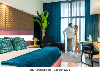 Horizontal photo with copy space of a happy couple kissing in a luxury hotel room upon arrival - Powered by Shutterstock