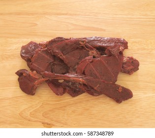 Horizontal Photo Of Deer Jerky On Wood Grain Table Top   