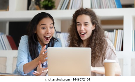 Horizontal Photo Excited Surprised Diverse Girls Looking At Laptop Screen, Reading Unexpected News, Great Offer, Shopping Sales, Asian And Caucasian Girls Students Received Successful Exam Results