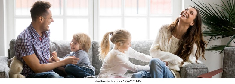 Horizontal Photo Kids Tickling Parents Happy Full Family Have Fun Sitting On Sofa In Living Room Leisure Activities Spend Time At Home Concept Banner For Website Header Design With Copy Space For Text