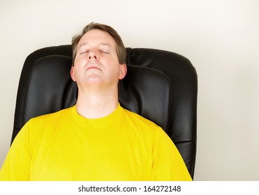 Horizontal Photo Of Mature Man Relaxing In Massage Chair With Eyes Closed