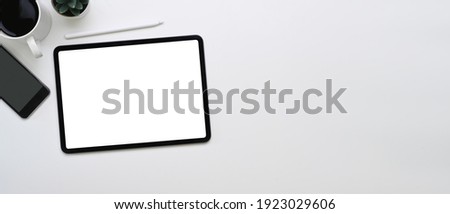 Horizontal photo of mock up digital tablet, smartphone, coffee cup and copy space on white background.