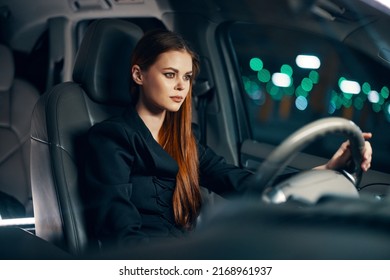 Horizontal Photo Of A Nice Woman In A Black Shirt Driving A Car While Driving At Night