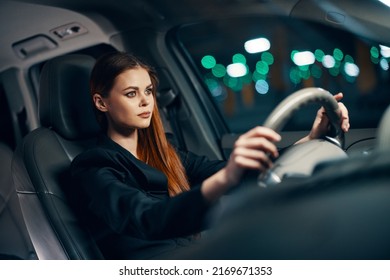 Horizontal Photo Of A Nice Woman In A Black Shirt Driving A Car While Driving At Night