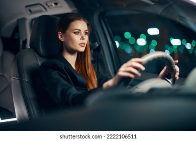 Horizontal Photo Of A Nice Woman In A Black Shirt Driving A Car While Driving At Night