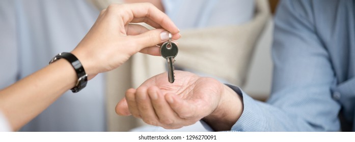 Horizontal Photo Reliable Real Estate Agent Giving Keys To Senior Couple, Male Female Hands Close Up, Spouses Buying New Home Receive Loan Mortgage Investing Concept, Banner For Website Header Design