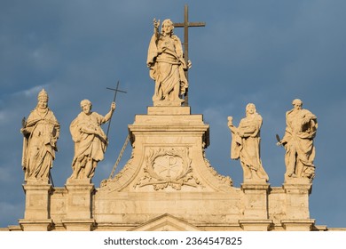 Horizontal photo of Sunlit Statues On The Top Of St John Lateran Basilica. Ancient, historical architecture, religious monuments, artistic sculptures. Captivating destination of rich history.