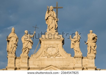 Horizontal photo of Sunlit Statues On The Top Of St John Lateran Basilica. Ancient, historical architecture, religious monuments, artistic sculptures. Captivating destination of rich history.