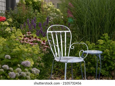 Horizontal Photo Of A Vintage Blue And White Metal Chair In The Middle Of A Garden Oasis