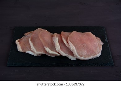 Horizontal Photo Of Whole Pork Tenderloin Raw Meat Is On A Black Slate 