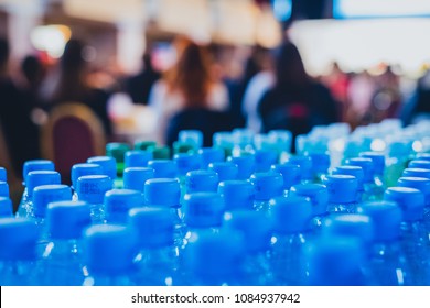 Horizontal picture of a multitude of blue bottle water caps on a business conference or a seminar, waiting for thirsty participants. - Shutterstock ID 1084937942