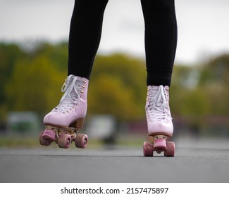 Horizontal Picture Of Person Rollerskating, Close Up Of Pink Vintage Quad Roller Skates. Concept: Leisure Activities. Movement, Summer, Sports, Vacations, Free Time, Outdoor Activities. 