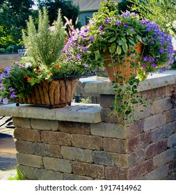 horizontal picture of a retaining wall with capstone ledges wide enough to hold terra cotta containers of herbs and flowers