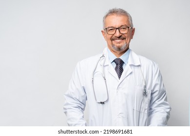 Horizontal Portrait of serious mature male doctor or therapist in white medical uniform, glasses and stethoscope, mature old man GP or physician in spectacles pose at white background healthcare - Powered by Shutterstock