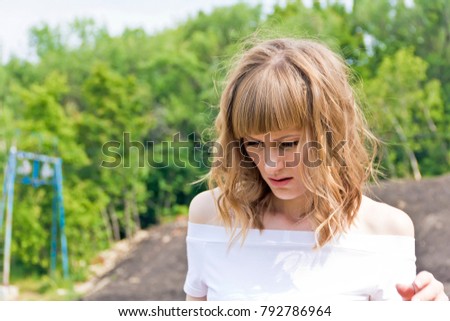 Horizontal portrait of young woman with blond hair on wood background