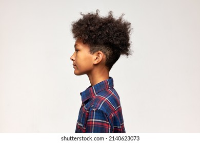 Horizontal Profile Portrait Of Serious Stylish Hipster Kid Of 13 In Trendy Red And Blue Plaid Flannel Shirt, Having Afro Hairstyle, Isolated Over White Studio Wall With Copy Space For Your Text