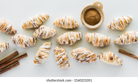 A horizontal row of mini cinnamon croissants drizzled with icing.  - Shutterstock ID 2160221051