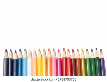 Horizontal Row of Sharpened Colored Pencils in Vibrant Rainbow Spectrum Isolated on White