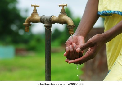 Horizontal Shot Of African Black Girl And A Water Tap In Africa