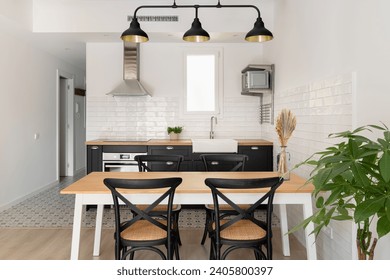 Horizontal shot of a black and white kitchen with a loft ceiling combined with a dining area overlooking the corridor. Concept of renovation in new building for a young couple - Powered by Shutterstock