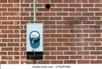 Horizontal Shot Of A Commercial Electric Meter On An Old Red Brick Wall With Copy Space.