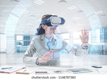 Horizontal shot of confident young business woman in suit using virtual reality headset and safety interface while sitting inside office building. - Powered by Shutterstock