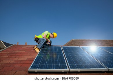 Horizontal Shot Of An Engineer Installing A Solar Panel On Roof Of A House On A Sunny Day With Copy Space.