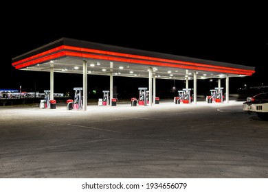 Horizontal shot of a generic unbranded gas station at night with copy space at the top and bottom.