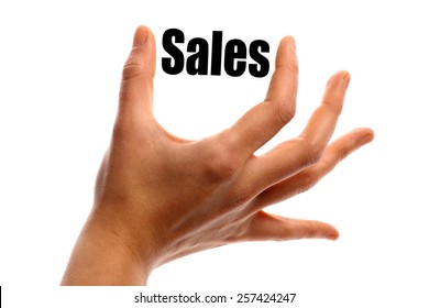 Horizontal shot of a hand holding the word "Sales" between two fingers, isolated on white.