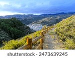 Horizontal shot of a hiking trail overlooking Quéntar, a traditional white village in the Sierra Nevada mountains near Granada, Andalusia, Southern Spain. 