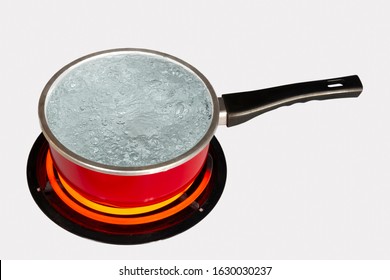 Horizontal Shot Looking Down On A Red Pot Of Boiling Water On Top Of A Stove With The Burner Turned To High.  White Background.  Copy Space.