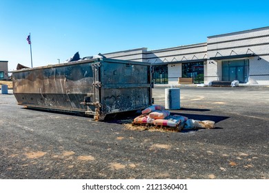 Horizontal Shot Of A Portable Dumpster Or Trash Trailer In Front Of A Commercial Construction Site.