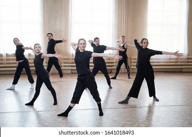 Horizontal shot of professional young dancers wearing black outfits reahearsing their new dance in studio - Powered by Shutterstock