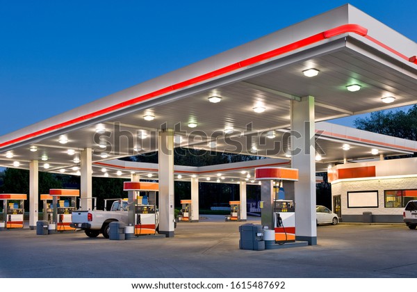 Horizontal shot of a retail gasoline station and\
convenience store at\
dusk.