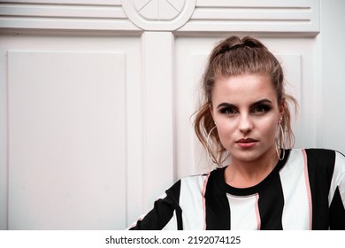 A Horizontal Shot Of A Young Caucasian Female With Hoop Earings Posing  At Daylight