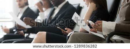 Horizontal side photo multinational applicants businesspeople sitting in queue waiting job interview holding resume papers using mobile phones, hr employment concept, banner for website header design