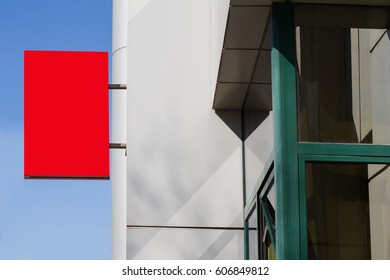 horizontal side view of empty red square signage on the exterior of a building