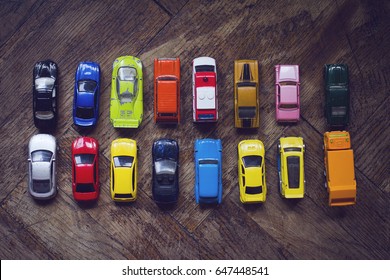 Horizontal Top View Assorted Metal Colorful Toy Car Collection On Brown Wooden Floor In Natural Light