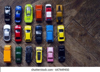 Horizontal Top View Assorted Metal Colorful Toy Car Collection On Brown Wooden Floor In Natural Light Copyspace