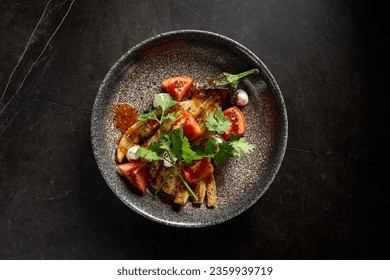 Horizontal top view of roasted eggplant with tomatoes, cilantro, and cheese on a stone plate, set against a minimalist black marble background, embodying pan-Asian flavors. - Powered by Shutterstock