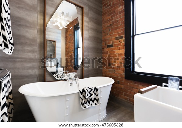 Horizontal version freestanding\
vintage style white bath tub in renovated warehouse\
apartment