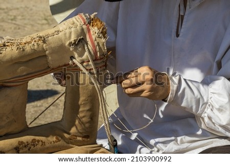 horizontal view in closeup of the hands of a saddler repairing an old horse saddle.saddlery is the art of working on various articles of leather or fittings for cavalry