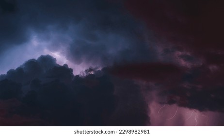 A horizontal view of the clouds and lightning in the sky. The photo has pink and blue tones.
