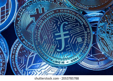 Horizontal view of cryptocurrency tokens, including Filecoin, Bitcoin, dogecoin, and ethererum seen from above on a black background. High quality photo