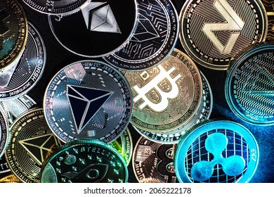 Horizontal view of cryptocurrency tokens, including Bitcoin, Tron, and Dash saw from above on a black background. High quality photo