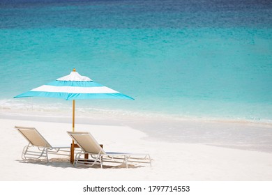 Horizontale Sicht auf leere Liegestühle auf dem Bild perfekter Strand mit türkisfarbener Lagune, Aqua-Menthe - Farbverlauf 2020, Kopienraum auf der rechten Seite