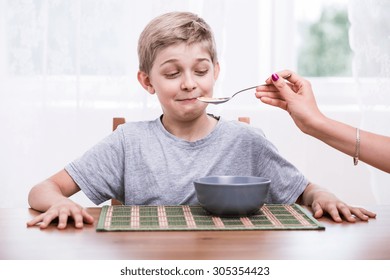 Horizontal View Of Mum Feeding Picky Eater