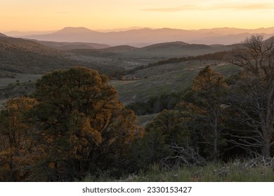 Horizontal view of the Pine Valley Mt. Utah from the top of a hill above the Water Canyon trail. The setting sun paints the landscape with warm light while a creek winds through the valley below.